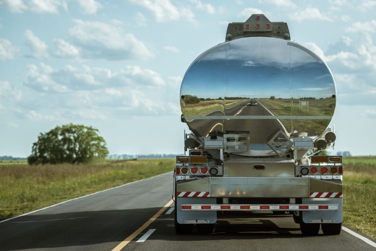 An oil and gas tanker driving on a road.